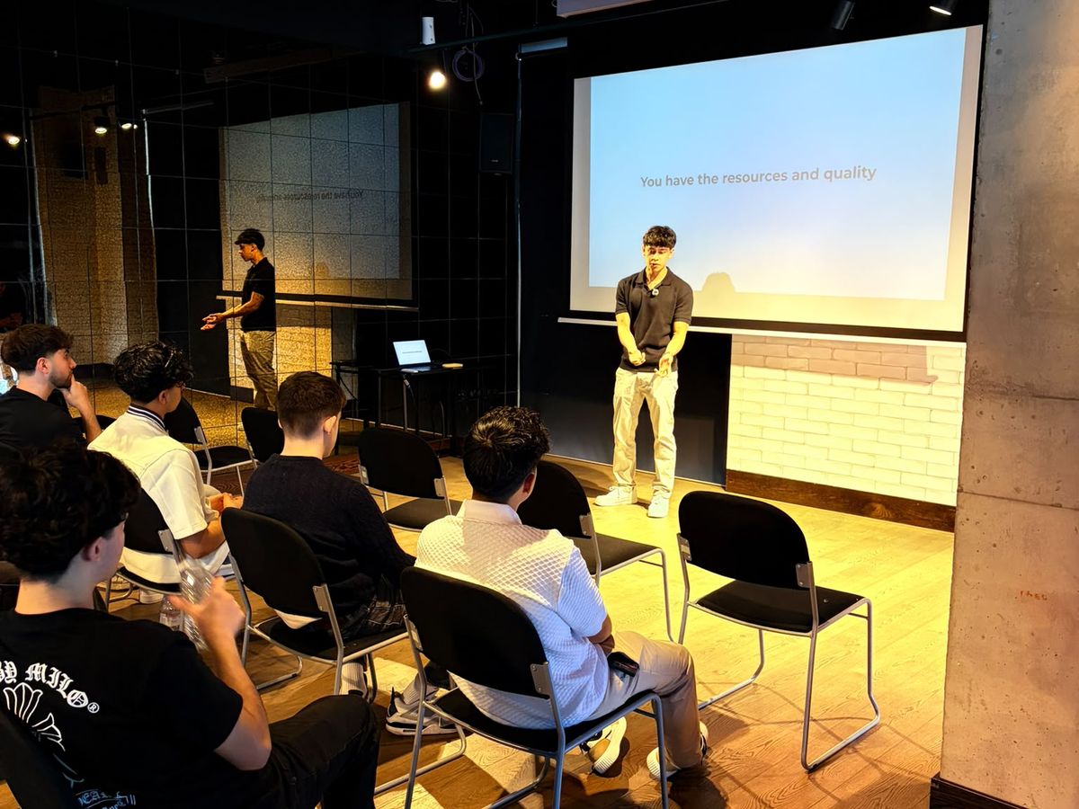 A speaker on stage presenting to a seated audience